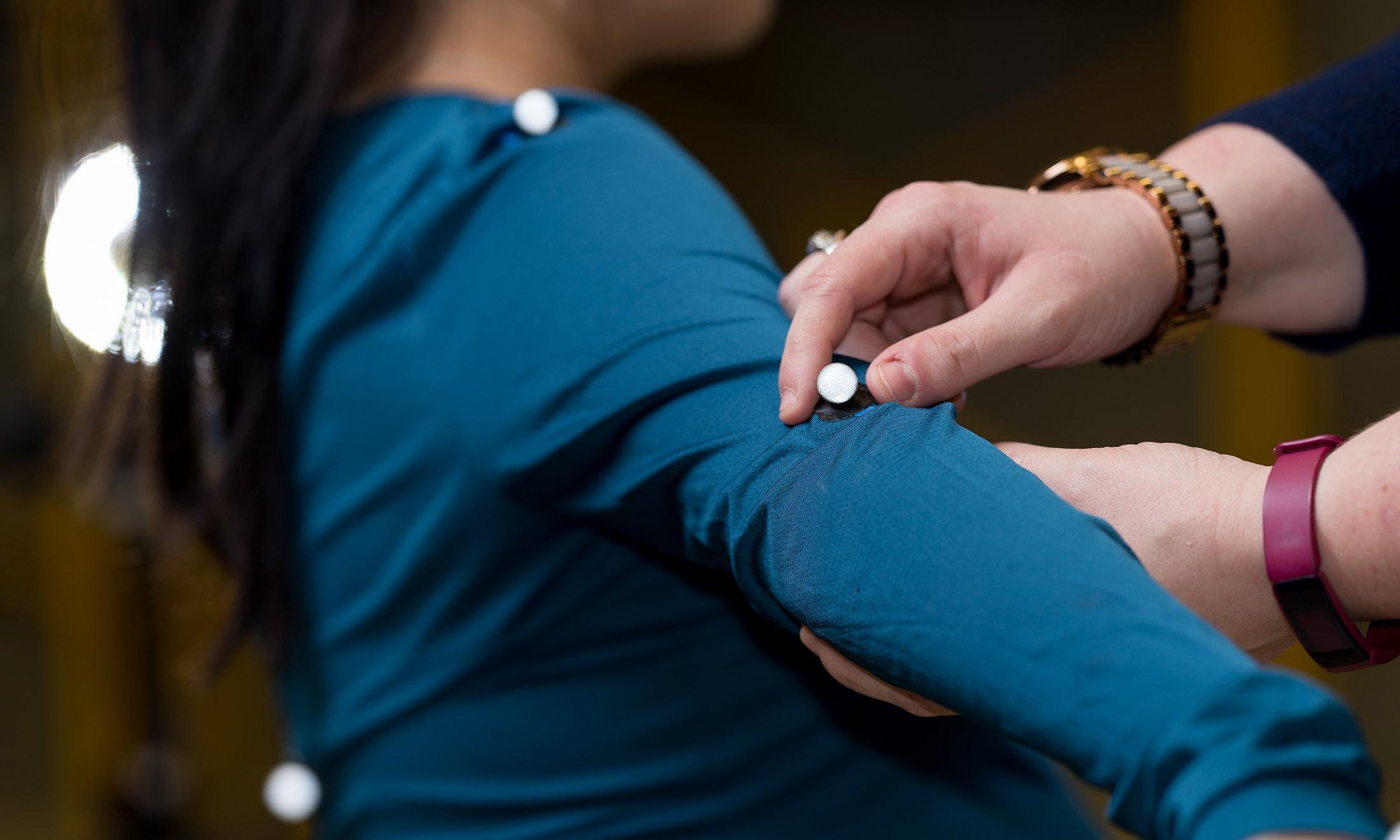 A woman placing motion detectors on another woman.