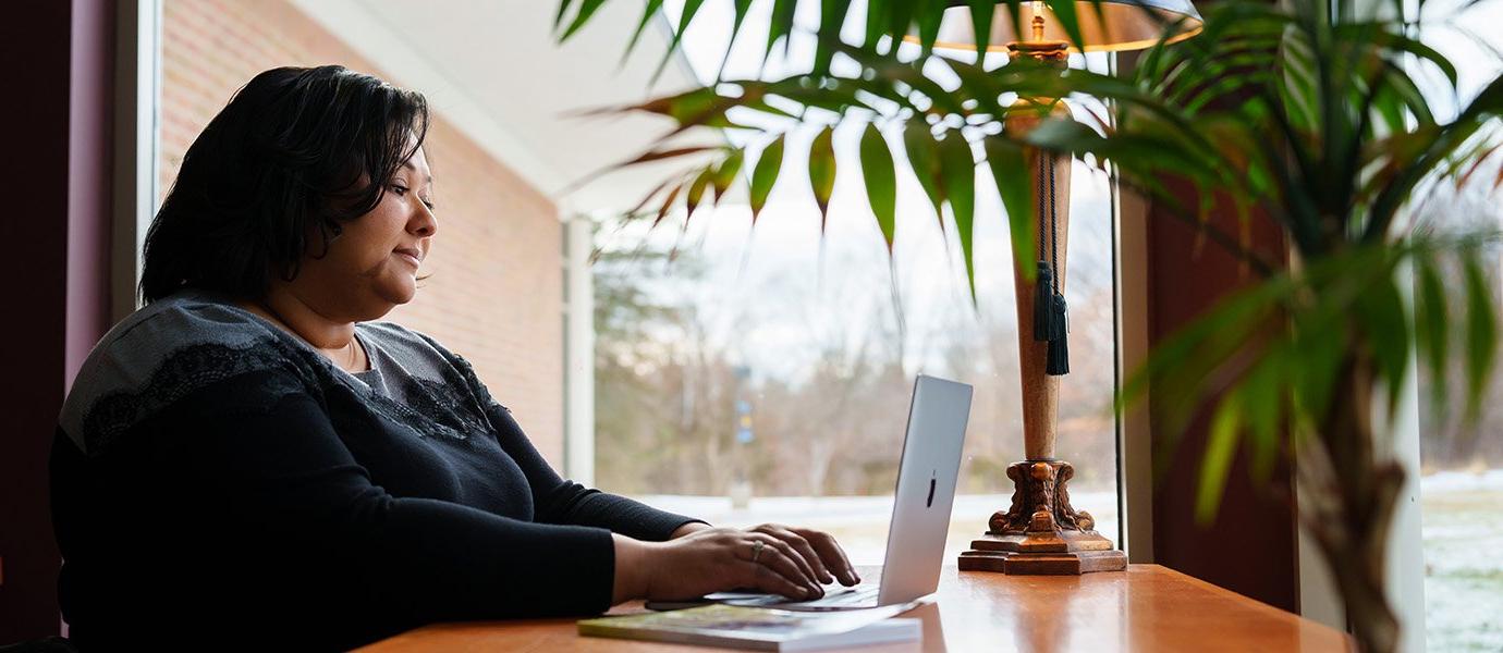 A woman at a desk in front of a window