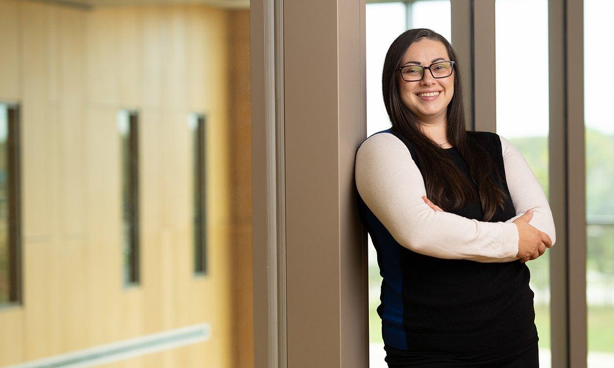 A woman in a hallways standing with her arms crossed.