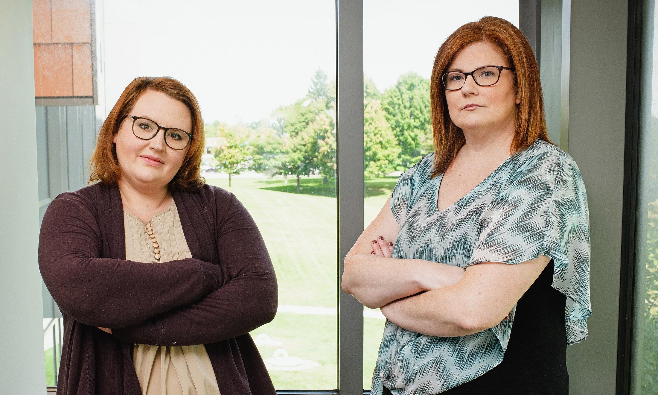 Two women posing with their arms crossed.